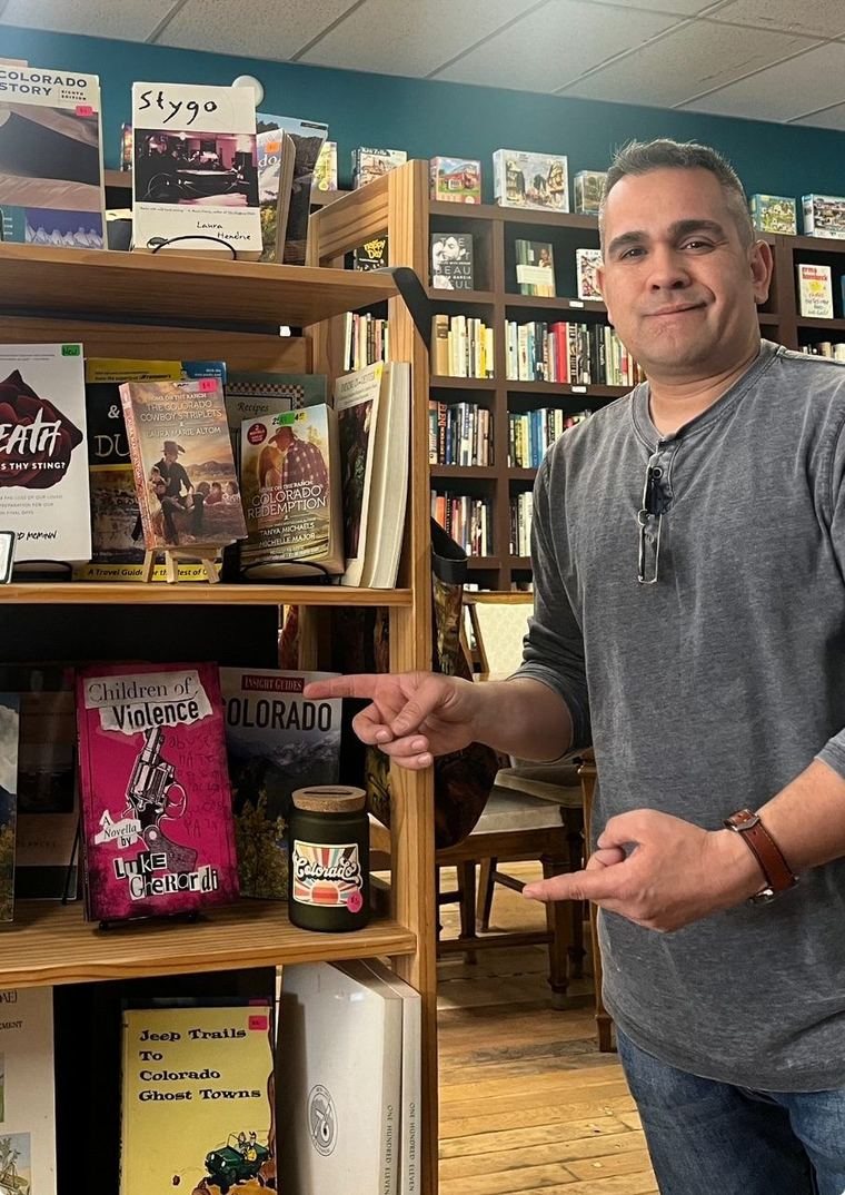 Luke Gherardi with Children of Violence on a bookstore shelf